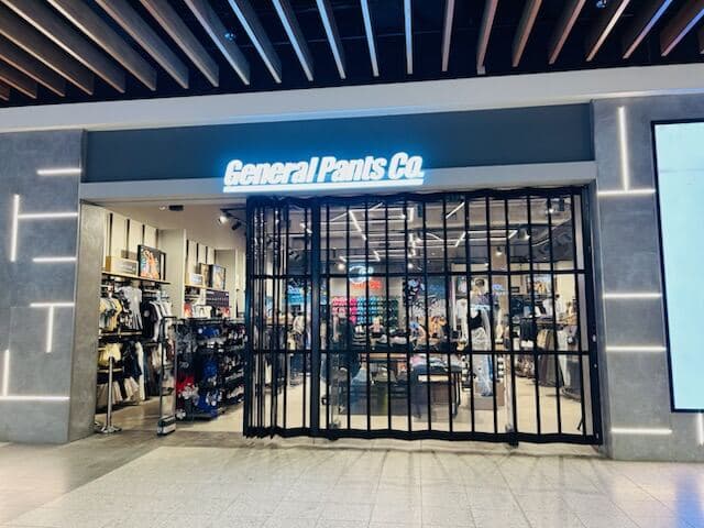 Completed General Pants Co. storefront with freshly painted grey façade and illuminated brand sign by VD Painting