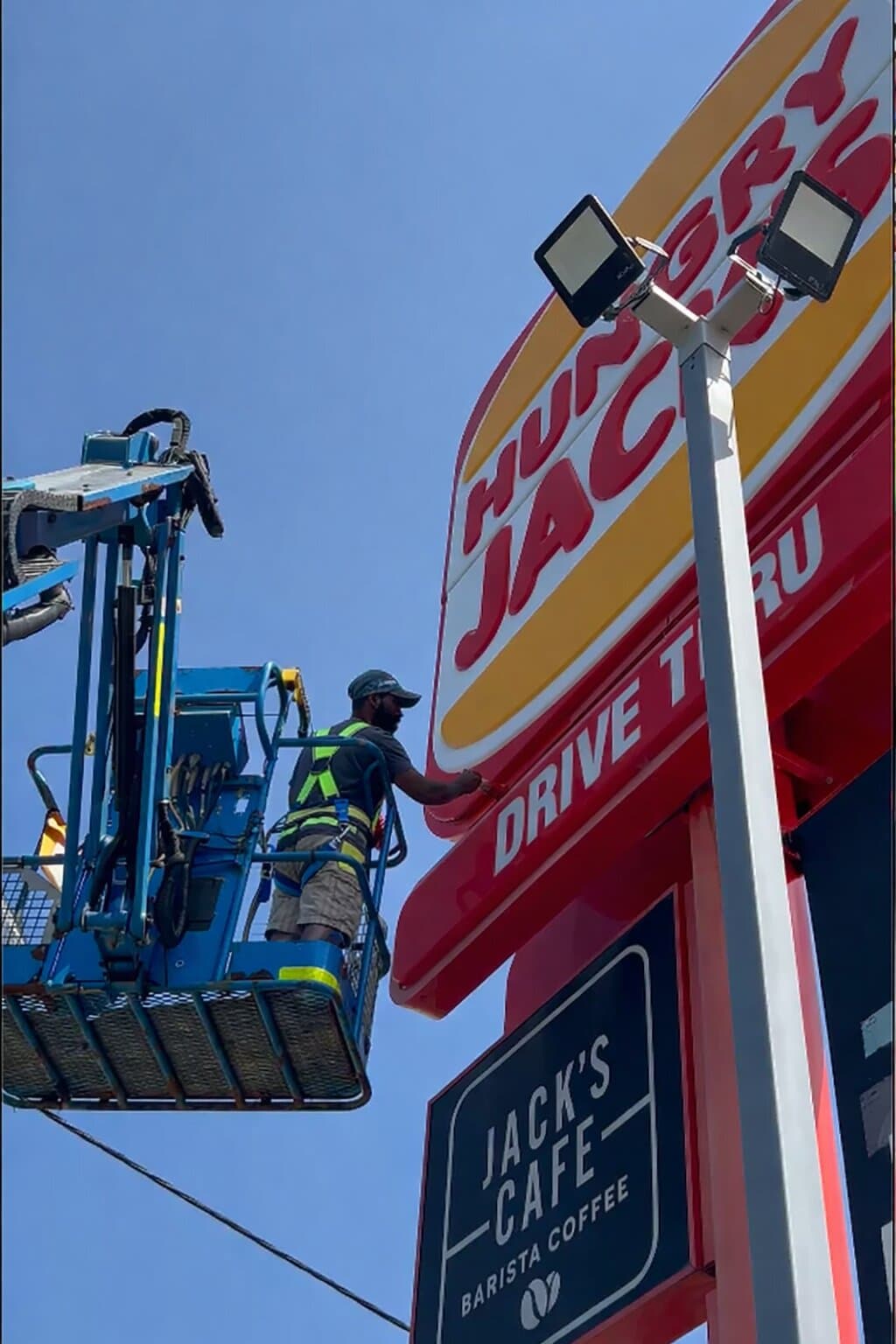 VD Painting crew repainting a Hungry Jack's Drive Thru sign from an elevated work platform